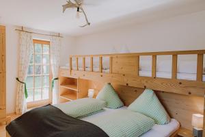 ein Schlafzimmer mit einem Etagenbett und grünen Kissen in der Unterkunft Guggi`s Alm in Dirlewang