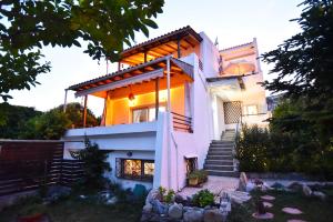 a house with stairs leading up to it at Fat Mermaid Seaside Villa in Paleo Tsifliki