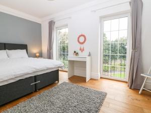 um quarto branco com uma cama e uma janela em Llechog em Amlwch