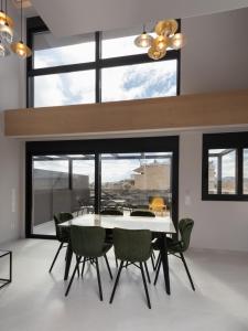 uma sala de jantar com uma mesa branca e cadeiras verdes em LUX&EASY Athens Downtown Residences em Atenas