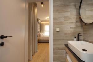 a bathroom with a white sink and a mirror at LUX&EASY Athens Downtown Residences in Athens