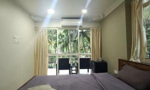 a bedroom with a bed and a large window at Kanvas Suites - Sun N Moon in Palolem