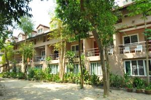 an apartment building with trees in front of it at Samed Villa Resort in Ko Samed