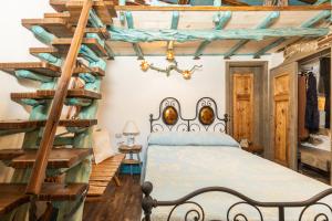 1 dormitorio con 1 cama con escalera de madera en Sa dommu de su maistru 'e linna_SA MOLA_, en Baunei