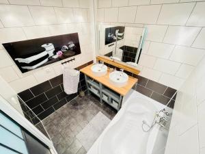 een badkamer met 2 wastafels, een bad en een spiegel bij Flatshare Colocation 2 close to Geneva in Saint-Genis-Pouilly