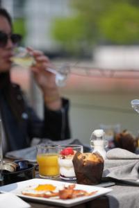 a woman sitting at a table with a plate of food at Hotel Restaurant Brasserie Feestzaal Ahoi, Kortrijk in Kortrijk