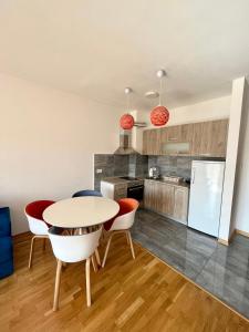ポドゴリツァにあるZ apartmentのテーブルと椅子のあるキッチンとダイニングルーム +3枚の写真