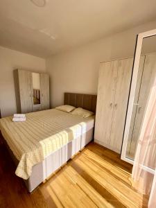 ポドゴリツァにあるZ apartmentのウッドフロアのベッドルーム1室(ベッド1台付)