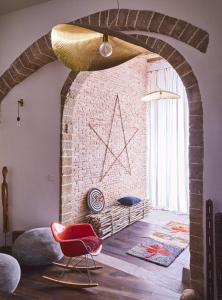a room with a brick wall and a red chair at Casa.b Mogador in Essaouira