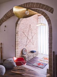 a room with a brick wall and a red chair at Casa.b Mogador in Essaouira +46 photos