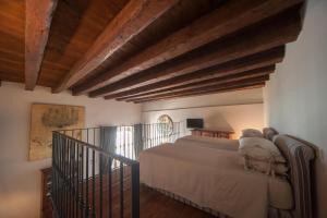 een slaapkamer met een bed in een kamer met houten plafonds bij Corte Kyrios Exclusive Suite XVIII Secolo in Trani