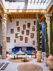 索維拉的住宿－Casa.b Mogador，客厅配有蓝色沙发和仙人掌