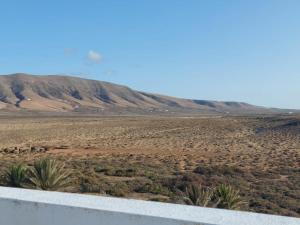 una vista de un desierto con una montaña en el fondo en Dunas de Famara, en Famara