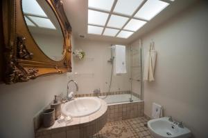 een badkamer met een wastafel, een spiegel en een bad bij Corte Kyrios Exclusive Suite XVIII Secolo in Trani +19 foto's