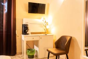 Zimmer mit einem Schreibtisch, einem Stuhl und einem TV in der Unterkunft B&B L'EDEN in Cassino