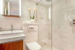 a bathroom with a toilet and a sink and a shower at The Artists Hideaway-2 bed mezzanine in Paddington in London