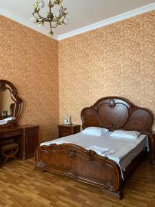 Un dormitorio con una cama grande y una lámpara de araña. en Guest House Eli, en Kutaisi