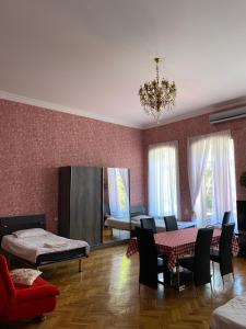sala de estar con mesa, sillas y lámpara de araña en Guest House Eli, en Kutaisi
