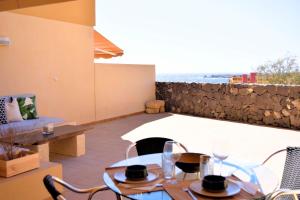 una mesa y sillas con vistas al océano en PillowAbroad - Sea view terrace Poris, en Porís de Abona