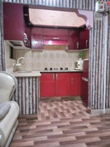 a kitchen with red cabinets and a counter top at Furnished One Bed Room Apartment Ground Floor With Kitchen in Karachi