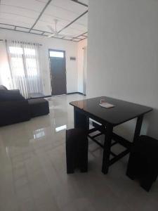 a black table in a room with a couch and a table at Juliya Guest House in Negombo