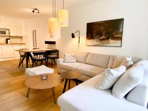 a living room with a white couch and a table at Appartement-Hotel Timmendorfer Strand in Timmendorfer Strand