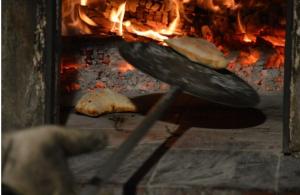 um fogão com duas fatias de pão em frente a uma fogueira em Casa Marietta em Forza dʼAgro