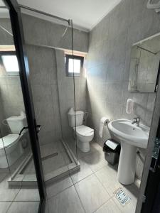 a bathroom with a toilet and a sink and a shower at Hotel Miniom in Constanţa