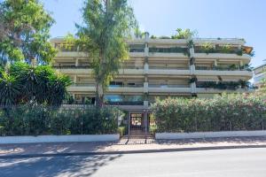 a large apartment building with flowers in front of it at Letmalaga Campos de Guadalmina in Marbella