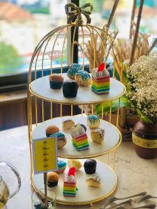 eine dreistufige Darstellung von Cupcakes und Muffins in der Unterkunft Happy Life Grand Hotel & Sky Bar in Ho-Chi-Minh-Stadt