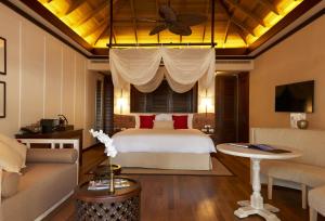 a hotel room with a bed and a couch at STORY Seychelles in Beau Vallon
