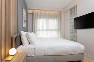 sypialnia z łóżkiem, oknem i telewizorem w obiekcie LUX&EASY Athens Downtown Residences w Atenach