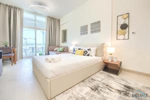 sypialnia z dużym łóżkiem i salonem w obiekcie Homely Studio in Azizi Aliyah Residence Al Jadaf by Deluxe Holiday Homes w Dubaju