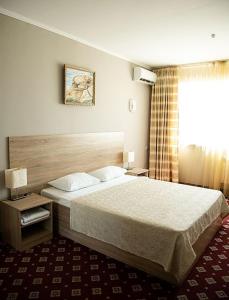 a hotel room with a bed and a window at Silk Way Hotel in Aktau