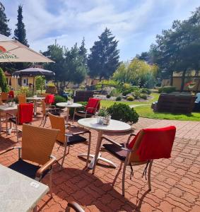 eine Terrasse mit Tischen und Stühlen auf einer Backsteinterrasse in der Unterkunft Hotel Pommerscher Hof in Zinnowitz