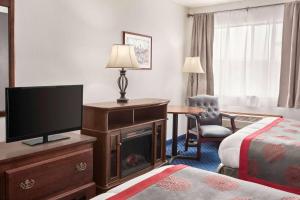 um quarto de hotel com uma televisão e uma cama em Ramada by Wyndham Arcata em Arcata