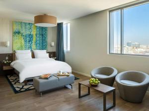 a hotel room with a bed and a large window at Adagio Jeddah City Center in Jeddah