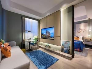 sala de estar con cama y TV en Novotel Shanghai Caohejing en Shanghái