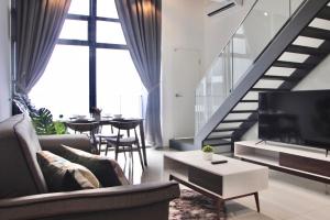 a living room with a couch and a tv and a table at Ekocheras Suite in Kuala Lumpur