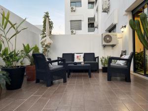 un patio con 2 sillas, una mesa y sillas en Picasso - Luxury apartment with swimming pool, en Casablanca