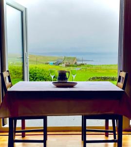 a table with two wine glasses and a view of the ocean at Sea View B & B in Ulsta