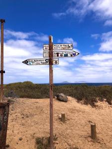 ein Holzschild mitten am Strand in der Unterkunft Dunas de Famara in Famara