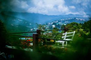 a white chair sitting on a balcony with flowers at Abu Homestay in Kohīma