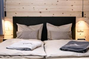 a bed with white blankets and pillows on it at Hoheneck Apartment in Mittelberg