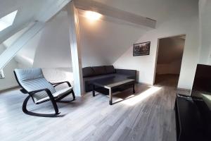 a living room with a chair and a couch at Spacious Work & Stay Apartments Büdesheim in Büdesheim