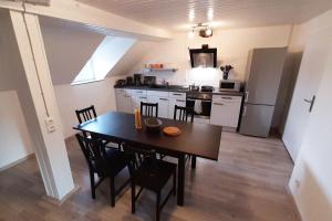 a kitchen with a table and chairs in a room at Spacious Work & Stay Apartments Büdesheim in Büdesheim