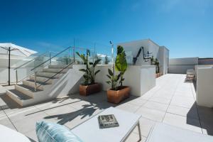 a balcony with stairs and plants on a building at Sercotel Sevilla Guadalquivir Suites in Seville