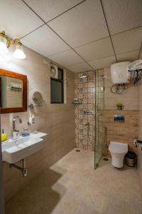a bathroom with a sink and a shower and a toilet at 35 Sahakar Suites-A Luxury Aparthotel in Jaipur in Jaipur