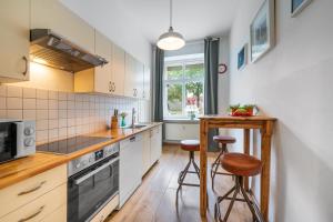 a kitchen with white cabinets and a counter with stools at Großes Apartment im Kiez in Berlin