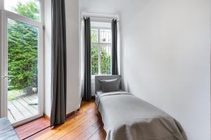 a bedroom with a bed and a large window at Großes Apartment im Kiez in Berlin